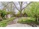 Lush backyard with mature trees and a brick paved path at 5017 E 14Th St, Indianapolis, IN 46201