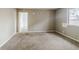 A bedroom features tan carpet, paint-ready walls, and natural light from a window at 5017 E 14Th St, Indianapolis, IN 46201