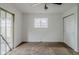 A bright carpeted bedroom features a ceiling fan, closet, and sliding glass door at 5017 E 14Th St, Indianapolis, IN 46201