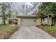 This is a detached garage with a concrete driveway surrounded by trees and foliage at 5017 E 14Th St, Indianapolis, IN 46201