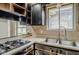 Kitchen is in progress with stainless double sink, gas stovetop, and upper cabinets removed at 5017 E 14Th St, Indianapolis, IN 46201