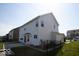 Rear view of the home, highlighting the patio area, fenced yard, and well-maintained lawn at 5051 Arling Ct, Indianapolis, IN 46237