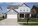 Charming two-story home featuring a brick-accented facade, attached garage, and a well-manicured front lawn at 5051 Arling Ct, Indianapolis, IN 46237
