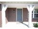 Welcoming front entry featuring a covered porch with brick columns and a gray front door at 5051 Arling Ct, Indianapolis, IN 46237