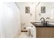 Bright bathroom with white cabinets, black countertop, modern fixtures, and a decorative framed mirror at 5124 Mccray St, Indianapolis, IN 46224