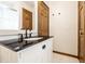 Updated bathroom featuring a black countertop, white cabinets, and a dark wood door at 5124 Mccray St, Indianapolis, IN 46224