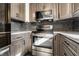 Close up of updated kitchen boasting stainless steel oven and gray cabinets at 5124 Mccray St, Indianapolis, IN 46224
