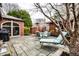 Cozy backyard patio with stone pavers, outdoor seating, a brick structure, and lush landscaping at 5157 N New Jersey St, Indianapolis, IN 46205
