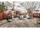 This backyard boasts an outdoor patio with brick flower mural, dining set, heater, lounge, and privacy fence at 5157 N New Jersey St, Indianapolis, IN 46205