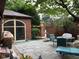 Enjoy this backyard stone patio with an outdoor dining area, grill, brick exterior, and colorful landscaping at 5157 N New Jersey St, Indianapolis, IN 46205