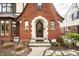Close-up of a brick Tudor-style home, showcasing the arched doorway and front entrance at 5157 N New Jersey St, Indianapolis, IN 46205