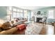Bright living room with a fireplace, large windows, hardwood floors, and comfortable furniture at 5157 N New Jersey St, Indianapolis, IN 46205