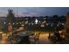 Cozy backyard patio with inviting stone fireplace and furniture, enhanced by string lights and overlooking a tranquil pond at twilight at 5178 Aegis Dr, Noblesville, IN 46062