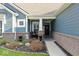 Inviting front porch with seating, brick accents, and professionally landscaped garden at 5178 Aegis Dr, Noblesville, IN 46062
