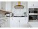 Close-up view of the kitchen with modern stainless-steel appliances, including double ovens and a gas cooktop at 5300 Veranda Dr, Noblesville, IN 46062