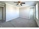 Large carpeted bedroom with a ceiling fan, neutral paint, and doorway to a walk-in closet at 5493 W Woodhaven Dr, McCordsville, IN 46055