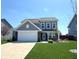 Charming two-story home with a well-manicured lawn, attached garage, and inviting front entrance at 5493 W Woodhaven Dr, McCordsville, IN 46055