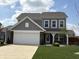 Charming two-story home with a modern gray exterior, brick accents, and a spacious garage at 5493 W Woodhaven Dr, McCordsville, IN 46055