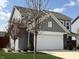 Attractive gray two-story home featuring a garage, well-manicured lawn, and mature landscaping at 5493 W Woodhaven Dr, McCordsville, IN 46055