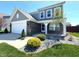 Well-maintained front yard with beautiful rock beds and healthy green grass leading up to a brick-accented facade at 5493 W Woodhaven Dr, McCordsville, IN 46055