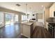Open kitchen with granite island, stainless appliances, and view of dining area with fireplace at 5493 W Woodhaven Dr, McCordsville, IN 46055