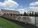 Community pool area with fencing, landscaping, and a clubhouse in a residential neighborhood at 5493 W Woodhaven Dr, McCordsville, IN 46055