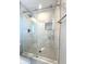 Modern bathroom shower with sliding glass door, marble tiling, and built-in niche for storage at 5493 W Woodhaven Dr, McCordsville, IN 46055