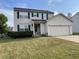 Charming two-story home with green shutters, landscaped yard, and attached two car garage at 5663 Rains Ln, Indianapolis, IN 46254
