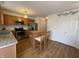 Bright kitchen featuring stainless steel appliances, white subway tile, wood cabinets, and breakfast bar at 5663 Rains Ln, Indianapolis, IN 46254