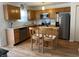 Bright kitchen featuring stainless steel appliances, white subway tile, wood cabinets, and breakfast bar at 5663 Rains Ln, Indianapolis, IN 46254