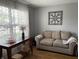 Cozy living room with hardwood floors, neutral paint, comfortable seating, and large window at 5663 Rains Ln, Indianapolis, IN 46254
