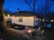 Backyard view of home with string lights, firepit and seating at dusk at 5739 E 62Nd Pl, Indianapolis, IN 46220