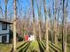 View of backyard with shed and partial view of house surrounded by bare trees on a sunny day at 5739 E 62Nd Pl, Indianapolis, IN 46220