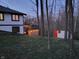 Backyard view of home with deck, string lights, shed at dusk at 5739 E 62Nd Pl, Indianapolis, IN 46220