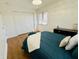 Comfortable bedroom featuring hardwood floors, a cozy bed, and natural light from the window at 5739 E 62Nd Pl, Indianapolis, IN 46220