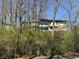 View of a house surrounded by trees, showcasing a multi-level design and natural setting at 5739 E 62Nd Pl, Indianapolis, IN 46220