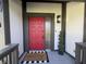 Stylish front door entrance with a red door, sidelight, and decorative houseplant at 5739 E 62Nd Pl, Indianapolis, IN 46220