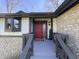 Close-up of a welcoming red front door with a stylish welcome mat and modern lighting at 5739 E 62Nd Pl, Indianapolis, IN 46220