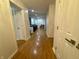 Bright hallway with gleaming hardwood floors, white walls, and access to other rooms at 5739 E 62Nd Pl, Indianapolis, IN 46220
