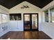 Bright living room with black ceiling, many windows, television, and hardwood floors at 5739 E 62Nd Pl, Indianapolis, IN 46220