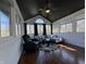 Bright sunroom with many windows, a ceiling fan, hardwood floors, and comfortable seating at 5739 E 62Nd Pl, Indianapolis, IN 46220