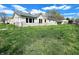 Large backyard with uncut grass and dandelions; the home has partial stone siding and many windows at 601 Duane St, Franklin, IN 46131