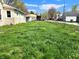 Spacious backyard with overgrown lawn, fenced in with chain link, and surrounded by neighborhood homes at 601 Duane St, Franklin, IN 46131