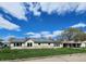 Low angle view of the home's exterior showing stone siding, updated windows, and a partially fenced yard at 601 Duane St, Franklin, IN 46131