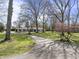 Ranch-style home with a long driveway and mature trees on a well-maintained lawn at 6025 Crows Nest Dr, Indianapolis, IN 46228