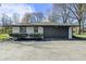 Charming single-story home featuring a gray garage door and a well-maintained front yard with lush landscaping at 6025 Crows Nest Dr, Indianapolis, IN 46228