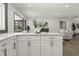 Open kitchen with white cabinets, quartz countertops, and views into living room through an open doorway at 6025 Crows Nest Dr, Indianapolis, IN 46228