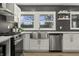 Well-lit kitchen with stainless steel appliances, white cabinets, herringbone tile backsplash, stainless farmhouse sink and natural light at 6025 Crows Nest Dr, Indianapolis, IN 46228