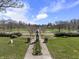 A peaceful park with walking paths, manicured lawns, mature trees, and benches under a bright sky at 6025 Crows Nest Dr, Indianapolis, IN 46228