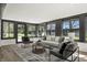 Cozy sun room with oversized windows, modern furniture, and a view of the private backyard at 6025 Crows Nest Dr, Indianapolis, IN 46228